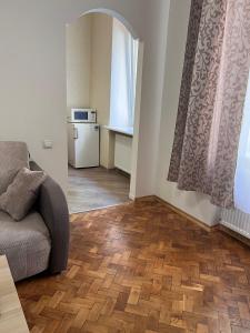 a living room with a couch and wooden floors at apartments of Saint Theodore in Lviv