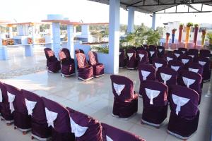 a group of chairs lined up in a room at H P HomeStay in Dhārwād
