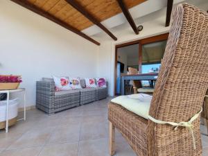 a living room with wicker chairs and a table at Residenza Porto Istana in Murta Maria