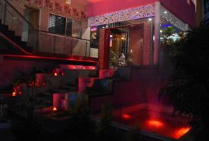 a fountain in front of a building with red lights at H P HomeStay in Dhārwād +8 photos