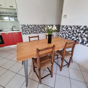 uma cozinha com uma mesa de madeira e 2 cadeiras em Casa La Robi em Mira