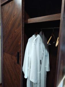 einen Schrank mit weißen Hemden, die darin hängen in der Unterkunft Dreamland Oasis in Chakvi