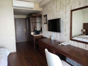Schlafzimmer mit einem Bett, einem Spiegel und einem Schreibtisch in der Unterkunft Dreamland Oasis in Chakvi