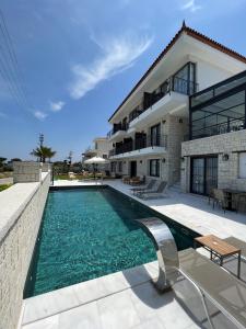 a swimming pool in front of a house at Vahide Dalyan in Cesme
