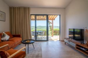 a living room with a couch and a tv and a table at Résidence Casarina in Bonifacio