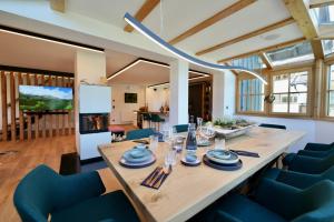 uma sala de jantar com uma mesa longa e cadeiras azuis em Lakeside Penthouse 16 by we rent em Zell am See