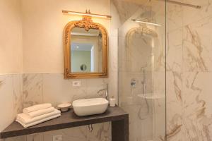 een badkamer met een wastafel en een douche met een spiegel bij Leopoldo in Baveno