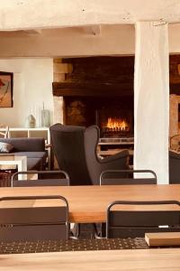 a restaurant with a fireplace and a table and chairs at Maison de famille du 17ème siècle 