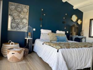 - une chambre avec un grand lit et un mur bleu dans l'établissement Villa contemporaine La Rochelle, à La Genilliere