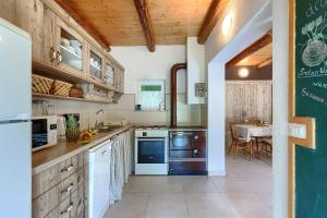 eine Küche mit weißen Geräten und einer grünen Tafel in der Unterkunft House Ana in Kanfanar