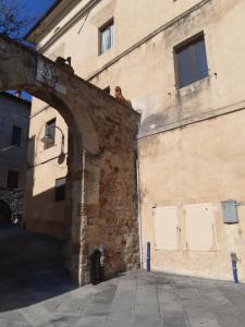 un antiguo edificio de ladrillo con un arco al lado en Casina del castello, en Castelnuovo della Misericordia