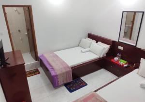 een kleine slaapkamer met een bed en een spiegel bij Hotel Muna Dhanmondi Six Floor in Dhaka