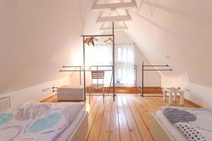 Habitación con 2 camas y lámpara de araña. en Ferienhaus- die KATE in Barth am Bodden, en Barth