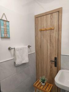 La salle de bains est pourvue d'une porte en bois et d'un lavabo. dans l'établissement Villa le Dodo - GBH, à Grand Baie