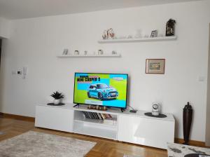 uma televisão em um centro de entretenimento branco em uma sala de estar em Noa em Ledine
