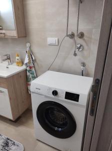 uma máquina de lavar roupa numa cozinha com um lavatório em Noa em Ledine