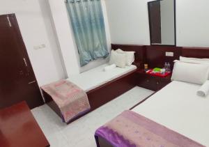 a small room with two beds and a window at Hotel Muna Dhanmondi Six Floor in Dhaka