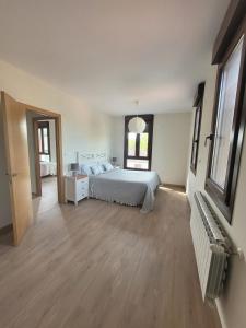 ein großes Schlafzimmer mit einem Bett und einem Holzboden in der Unterkunft Casa do Porto 