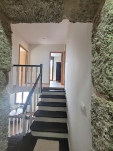 eine Treppe in einem Haus mit einer Steinmauer in der Unterkunft Casa do Porto 