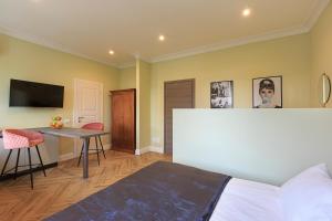 a bedroom with a bed and a desk and a tv at Leopoldo in Baveno
