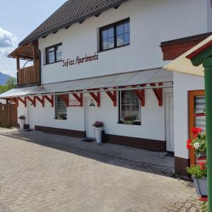 a white building with red flags in front of it at Sofias Apartment in Bad Goisern