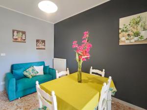 una sala de estar con una mesa con un jarrón de flores. en Sole Paola, en Anzio