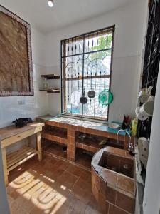 um quarto com uma janela com um banco e uma mesa em EAST SANDBANK apartment eco-friendly Nungwi airport road em Nungwi