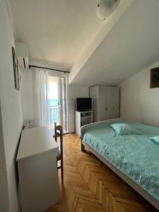 ein Schlafzimmer mit einem Bett, einem Schreibtisch und einem Fernseher in der Unterkunft Apartman Marinac in Podstrana + 33 Fotos