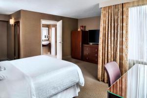 a hotel room with a bed and a television at Sheraton Centre Toronto Hotel in Toronto