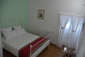 a small bedroom with a bed and two windows at La Little School Chambres d'Hôtes à Arçay in Arçay