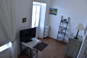 a living room with a television and a white table at La Little School Chambres d'Hôtes à Arçay in Arçay