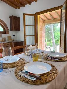 una mesa con platos y copas de vino. en La Cantina del Podere dei Boni, en Fauglia