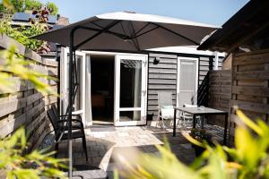 eine Terrasse mit einem Tisch und einem Sonnenschirm in der Unterkunft Appartement Wadpier in Buren