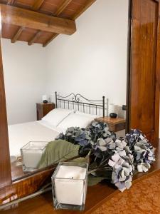 um quarto com uma cama e uma mesa com flores em La Cantina del Podere dei Boni em Fauglia