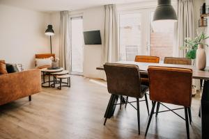 a living room with a dining room table and chairs at Appartement Wadpier in Buren