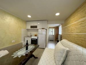 a kitchen with a couch and a table and a refrigerator at Pejovic apartmani Mojkovac in Mojkovac