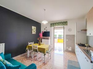 eine Küche und ein Esszimmer mit einem gelben Tisch und Stühlen in der Unterkunft Sole Paola in Anzio