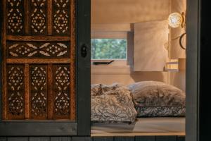 a bedroom with a bed next to a window at Pipowagen de Zwerveling aan zee in Oostkapelle