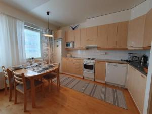 a kitchen with a wooden table and a dining room at Rovaniemi Ruokasenkatu apt - Wi-Fi - Sauna - Free Parking in Rovaniemi