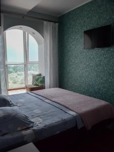 a bedroom with a large bed and a window at Apartment on Parkova 36 in Chornomorsk