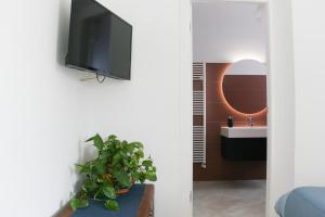 uma casa de banho com um lavatório e uma televisão na parede em Al Borghetto em Piazza Armerina