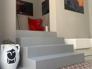 a set of white stairs with a vase in a room at Donna Caterina in Monopoli
