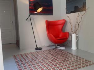 a red chair in a room with a lamp and a rug at Donna Caterina in Monopoli