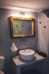 y baño con lavabo y espejo. en Castria studios, en Kionia