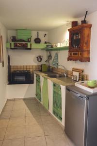 uma cozinha com armários verdes e brancos e uma máquina de lavar louça em Castria studios em Kionia