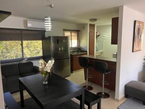 ein Wohnzimmer mit einem schwarzen Tisch und eine Küche in der Unterkunft Serenity III in La Estrella