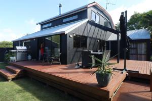 una casa con una terraza con una maceta. en Mapua Fernz en Mapua