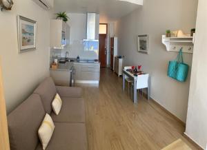 uma sala de estar e cozinha com um sofá e uma mesa em Touch the Sea em Sardina