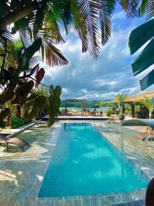 a swimming pool with blue water in a resort at Villa Pantai Secret Place in Miracatu