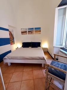 ein Schlafzimmer mit einem Bett und zwei Fenstern in der Unterkunft Il Balconcino sul carugio in Monterosso al Mare